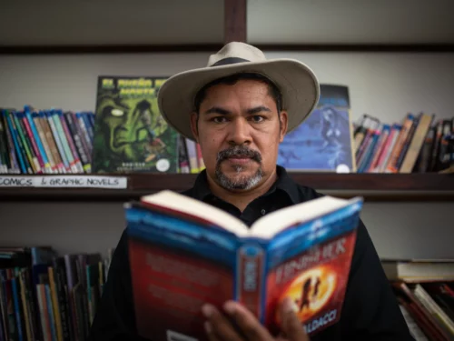 Ronald Díaz lee una de sus historietas en la biblioteca.